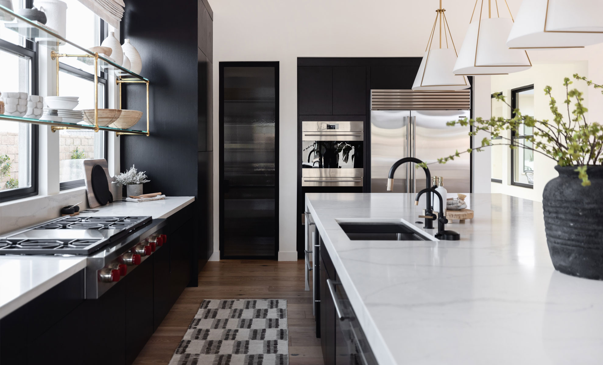 A minimalist quartz countertop is surrounded by black cabinetry, creating a bold yet minimalist kitchen space.
